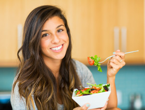 Portrait of beautiful young woman eating a bowl of healthy organ